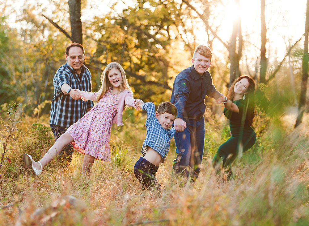 Family laughing with a soft sunset glow.
