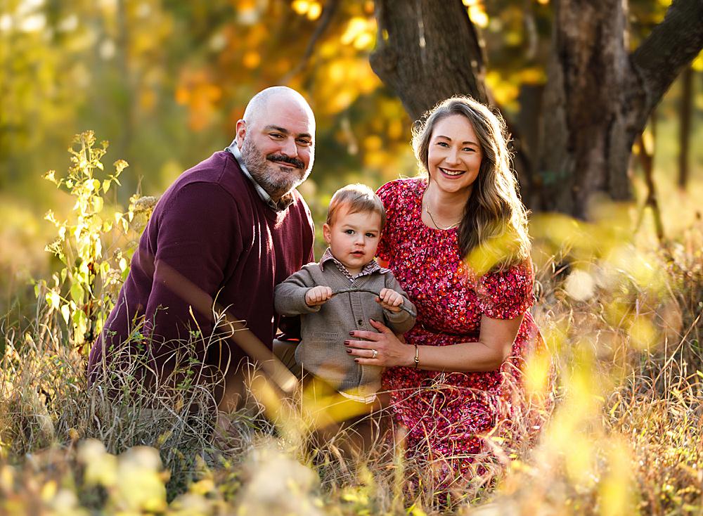 family with one child laughing during golden hour in Bucks County, PA